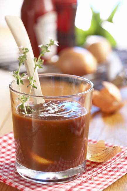 Homemade barbecue sauce with cola in glass over cloth — Stock Photo