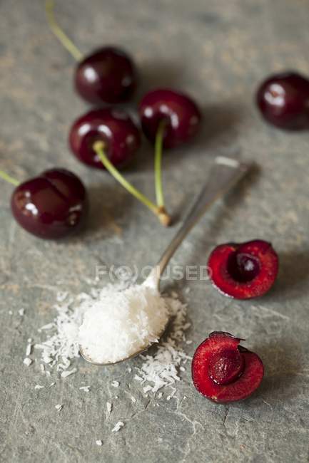 Fresh cherries and coconut flakes — Stock Photo