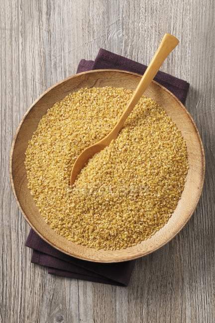 Raw bulgur in a wooden bowl — Stock Photo