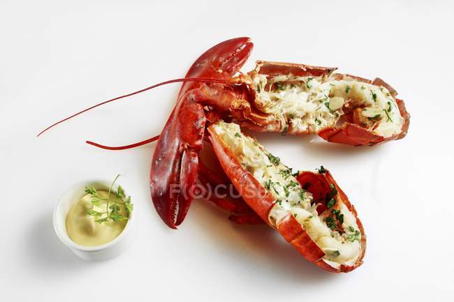 Vue rapprochée du homard coupé en deux avec mayonnaise sur la surface blanche — Photo de stock