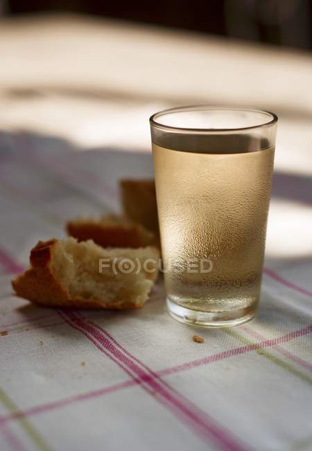 Copa de vino blanco y pan - foto de stock