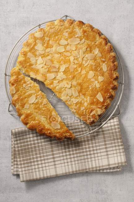 Sliced Almond cake on cooling rack — Stock Photo