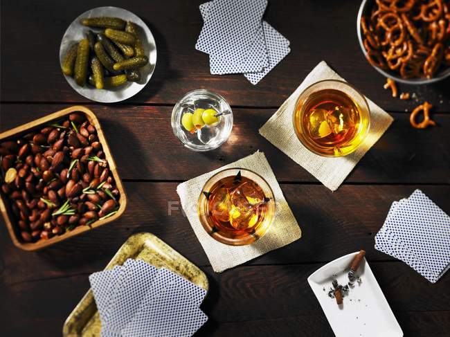 Top view of playing cards with drinks and snacks on table — Stock Photo