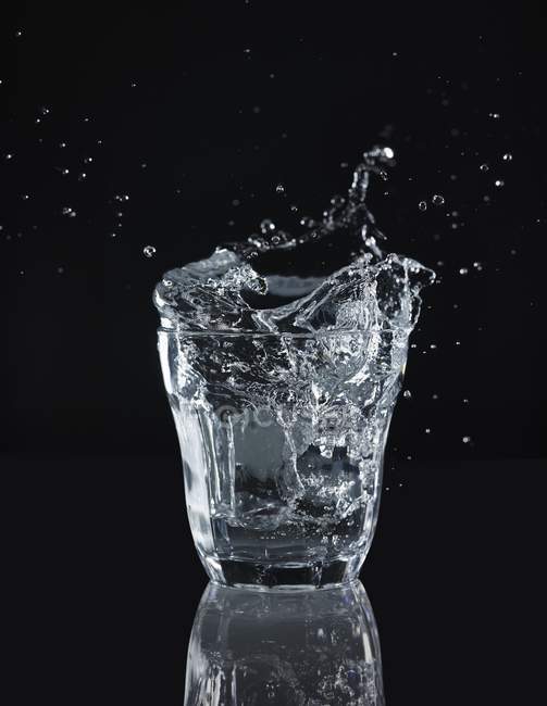 Spruzzi d'acqua da un bicchiere — Foto stock