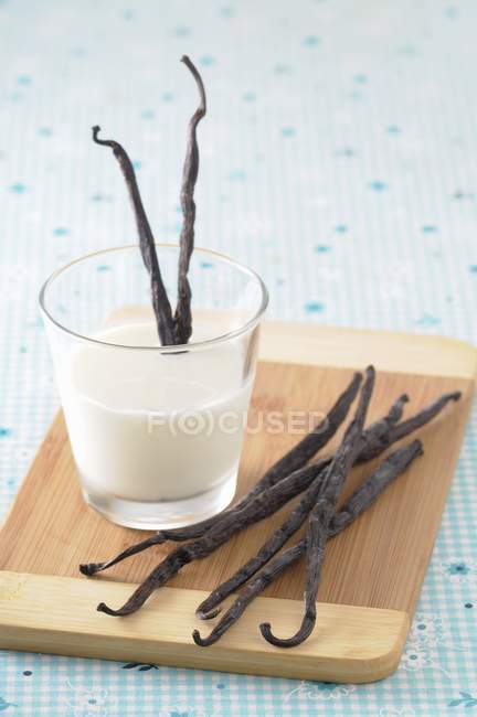 Bicchiere di latte con baccelli di vaniglia — Foto stock