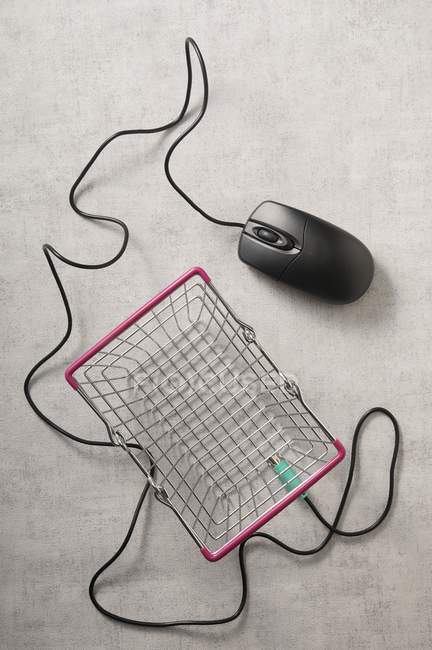Une image représentative des achats en ligne avec une souris d'ordinateur et un panier de fils — Photo de stock