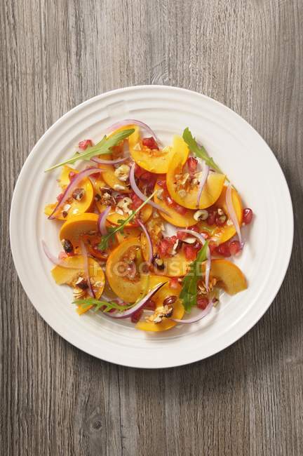 Kürbissalat mit Granatapfelkernen und Zitronenconfit auf weißem Teller — Stockfoto