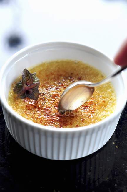 Closeup view of Creme brulee with spoon — Stock Photo