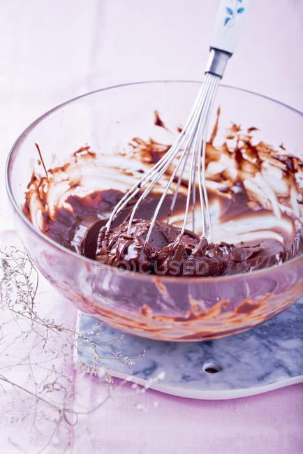 Closeup view of chocolate icing in mixing bowl with whisk — Stock Photo