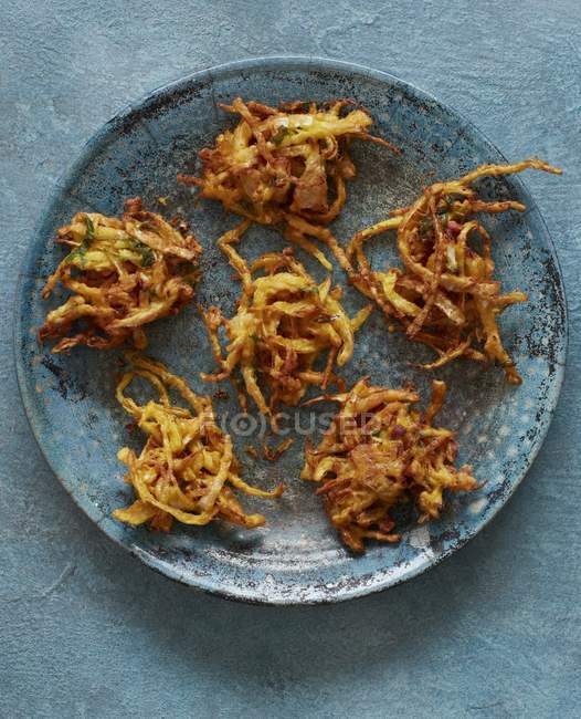 Cabbage bhaji on green plate over rustic green surface — Stock Photo