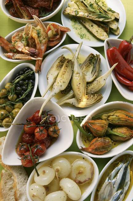Antipasti assortiti: verdure in salamoia, pesce, scampi in ciotole e piatti — Foto stock