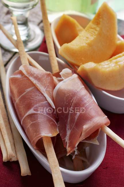 Parma ham with grissini and melon — Stock Photo