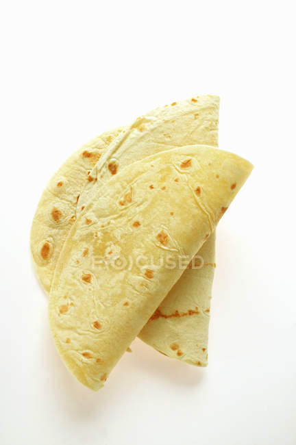 Vue rapprochée des tortillas pliées sur la surface blanche — Photo de stock