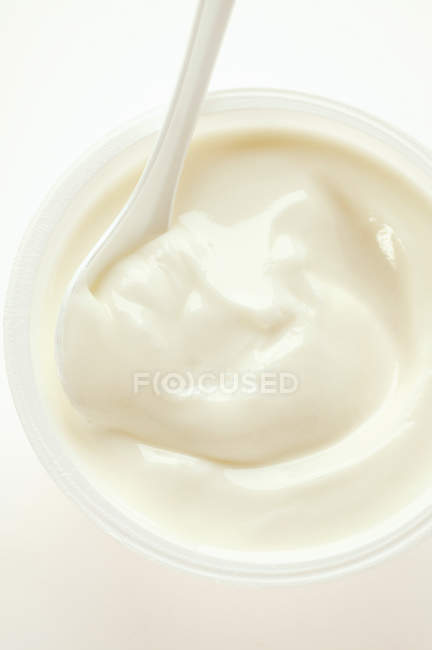 Yoghurt in pot with spoon — Stock Photo