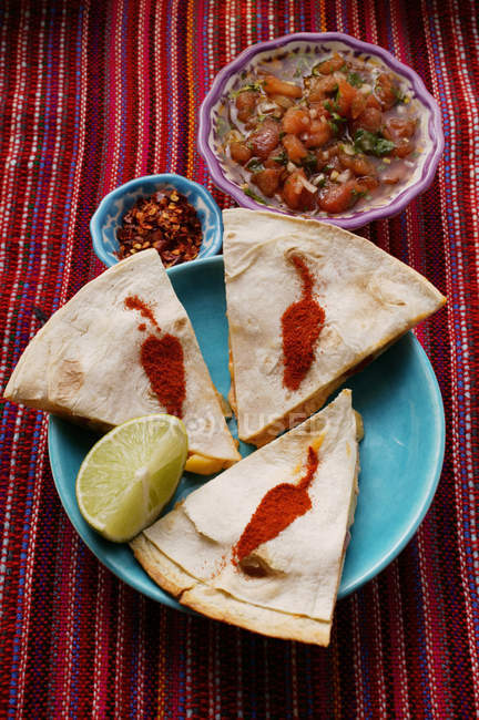 Vue surélevée des crevettes Enchiladas à la salsa de tomates et flocons de piment — Photo de stock