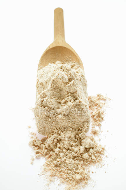 Wholemeal flour on wooden scoop — Stock Photo