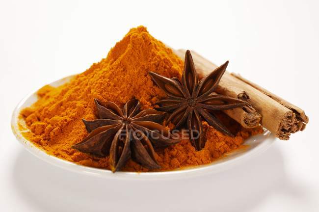 Closeup view of curry powder with star anise and cinnamon sticks — Stock Photo
