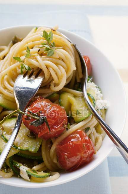 Espaguetis con tomates cherry y calabacines - foto de stock