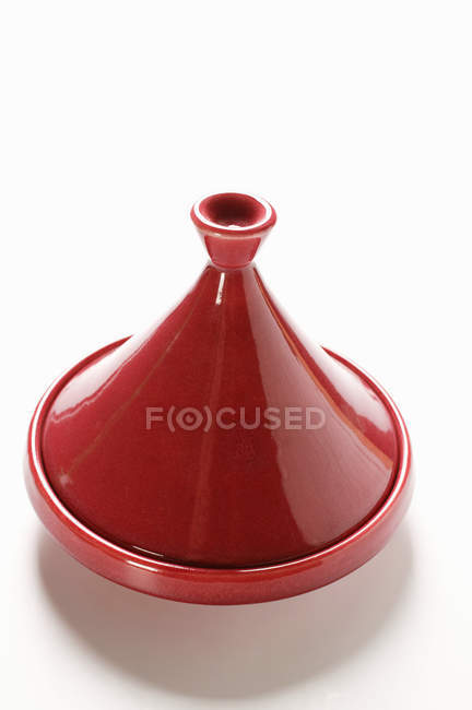 Vista close-up de prato Tajine vermelho na superfície branca — Fotografia de Stock