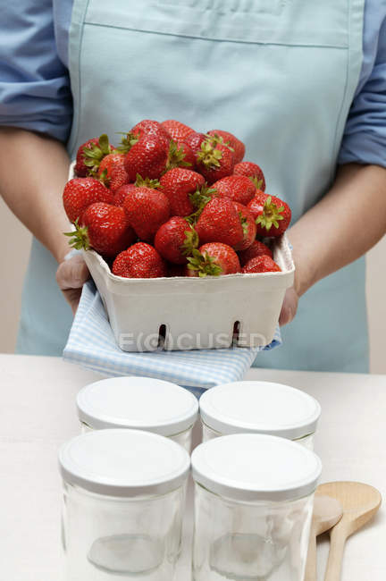 Femme tenant boîte de fraises — Photo de stock