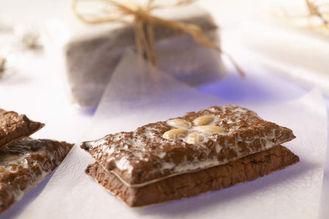 Closeup view of gingerbread with almonds on paper — Stock Photo