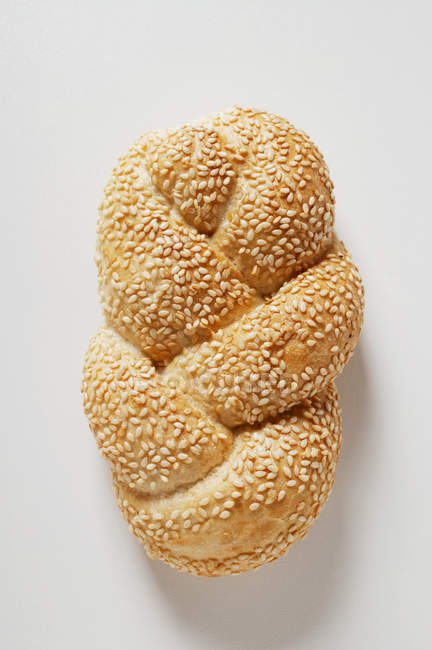 Closeup top view of one sesame plait on white surface — Stock Photo