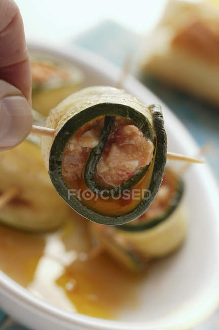 Courgette rolls with mozzarella and tomato filling in hand — Stock Photo