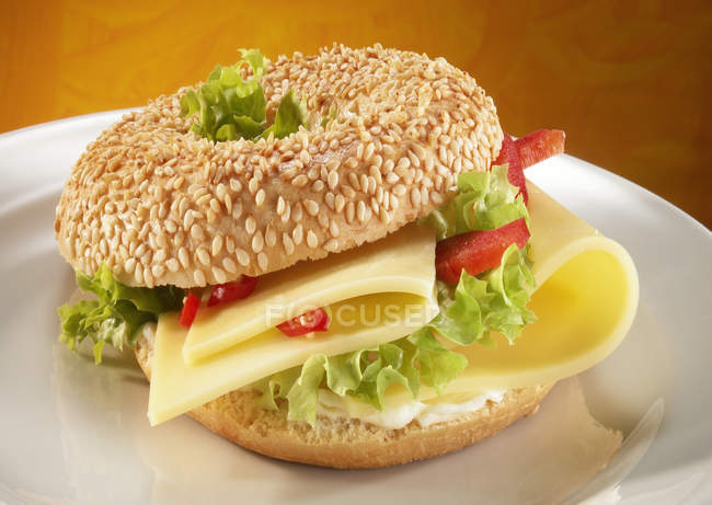 Sesame bagel on white plate — Stock Photo