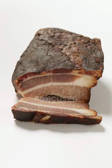 Partly sliced Organic smoked bacon — Stock Photo