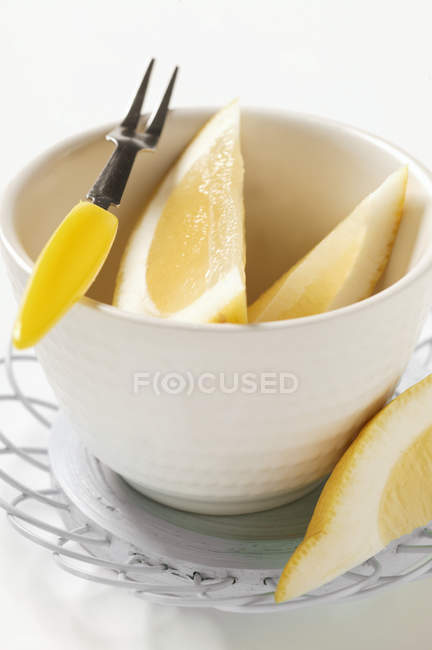 Cuñas de limón en un tazón pequeño - foto de stock