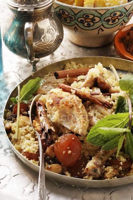 Closeup view of couscous with chicken, dried fruit, almonds and cinnamon — Stock Photo