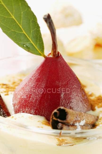 Крупним планом подання груші в червоному вині з корицею у Мадейрі вершках — стокове фото