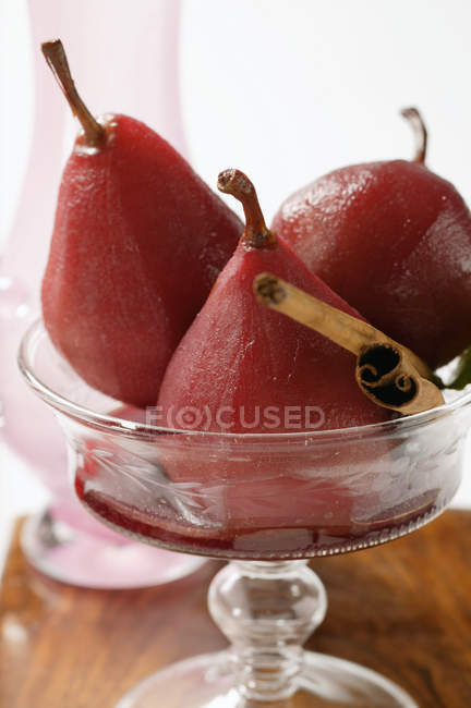 Vue rapprochée des poires dans le vin rouge à la cannelle — Photo de stock