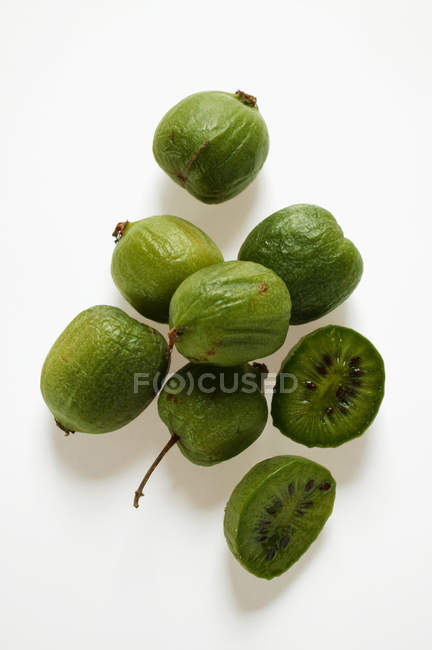 Mini-kiwi frutas inteiras e cortadas pela metade — Fotografia de Stock