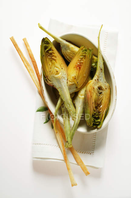 Marinated artichokes with grissini — Stock Photo