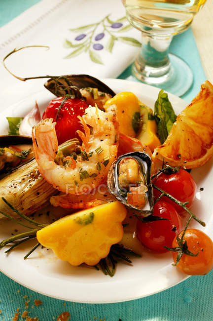 Плита средиземноморских закусок морепродукты, овощи на зеленой деревянной поверхности — стоковое фото