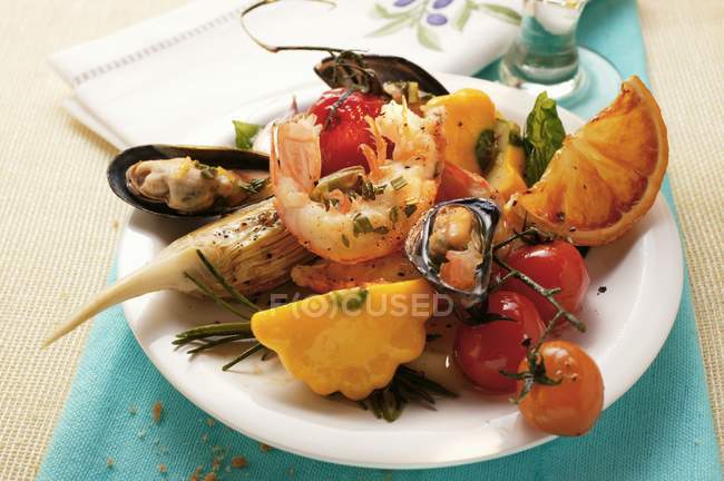 Placa de aperitivos mediterráneos, mariscos, verduras en plato blanco sobre toalla azul - foto de stock
