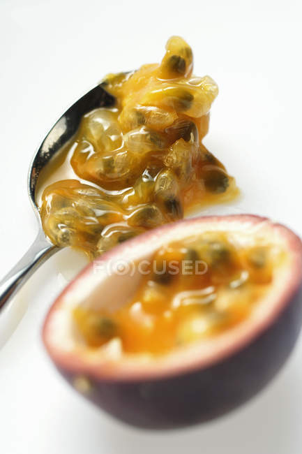 Spooning out passion fruit flesh — Stock Photo