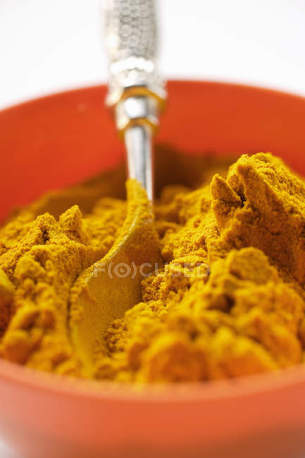 Curcuma in ciotola d'arancia con cucchiaio — Foto stock