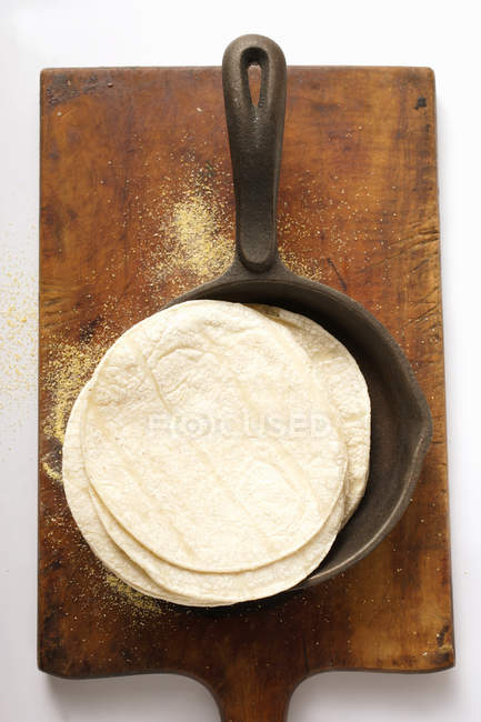 Wheat Tortillas pile in frying pan on chopping board — Stock Photo
