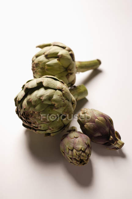 Cuatro alcachofas verdes - foto de stock