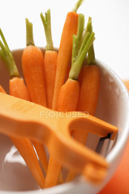 Cenouras descascadas em copo branco — Fotografia de Stock