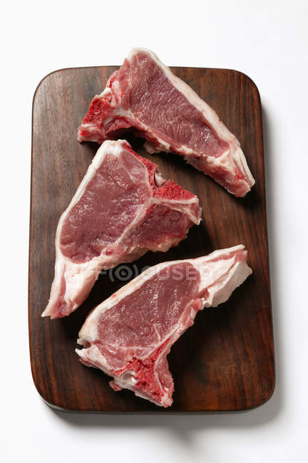Lamb cutlets on chopping board — Stock Photo