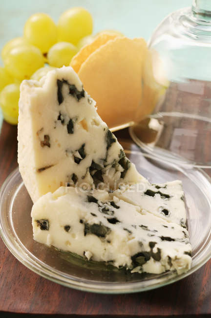 Roquefort cheese pieces and green grapes — Stock Photo