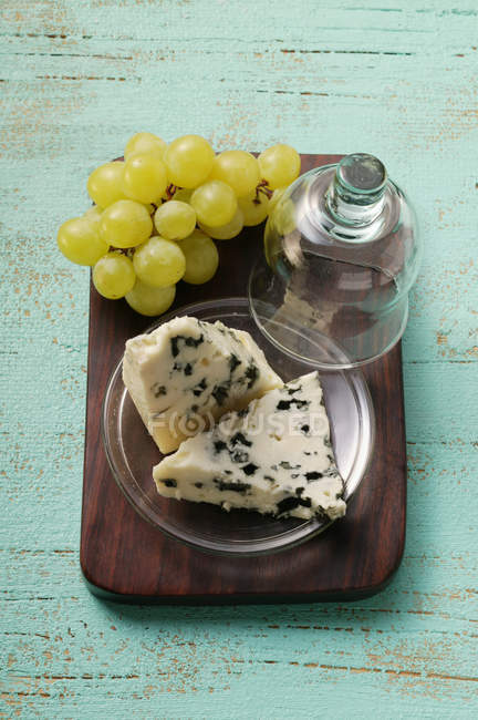 Roquefort cheese pieces and green grapes — Stock Photo