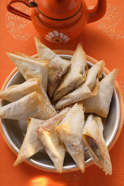 Top view of filled triangular pastries in bowl — Stock Photo