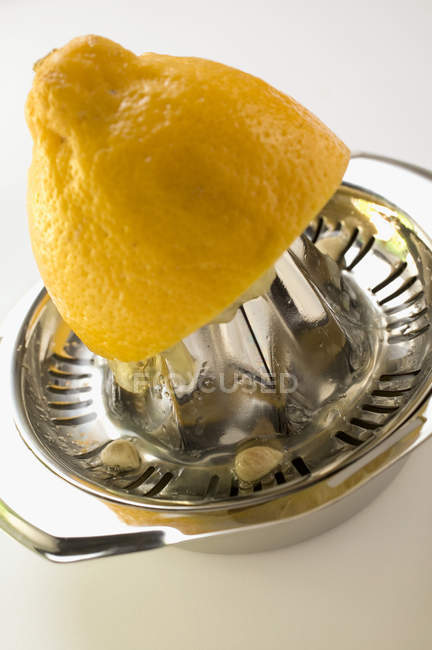 Лимон с цитрусовым прессом — стоковое фото