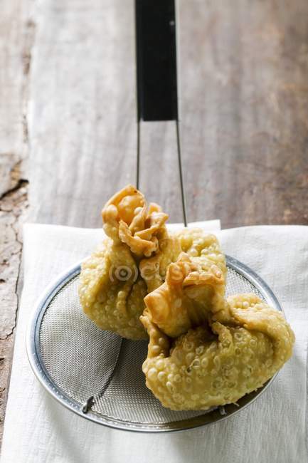 Vue rapprochée de deux Wontons frits sur cuillère filtrante — Photo de stock