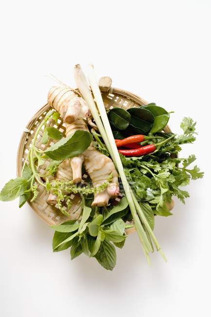 Ervas e especiarias tailandesas frescas em cesta sobre fundo branco — Fotografia de Stock