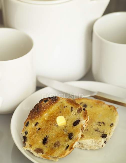 Closeup view of toasted bun halves with raisins and butter — Stock Photo
